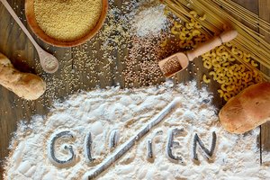 Weisses Mehl mit Gluten Schriftzug mit diversen gemahlenen Getreidesorten 